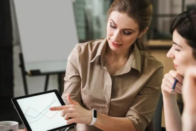 Profissional apresentando análise de dados em um tablet durante uma reunião sobre como transformar dados em conteúdo usando analytics